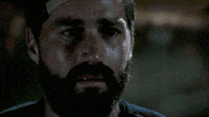 Gif image from LOST of white man with black hair and beard wearing bandage on forehead, looking disheveled and yelling, with caption in white caps reading WE HAVE TO GO BACK